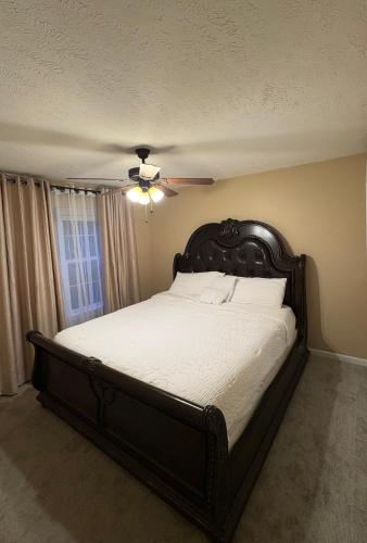 a bedroom with a large bed with a ceiling fan at The Universal Home Stay in Akron