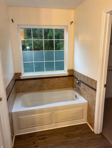 a bath tub in a bathroom with a window at The Universal Home Stay in Akron