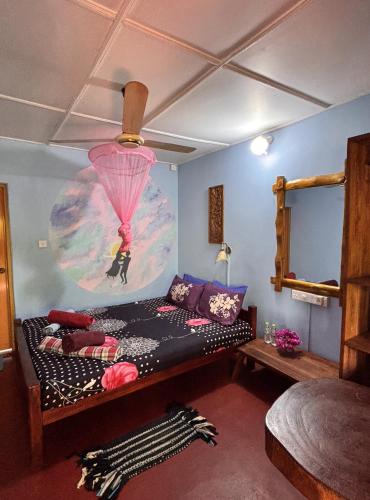 a bedroom with a bed and a painting on the wall at Lobster Inn in Trincomalee