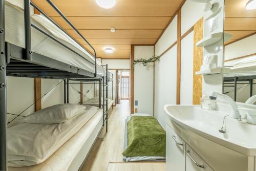 a bedroom with a bunk bed and a sink at Guesthouse Ichiedo in Kashihara