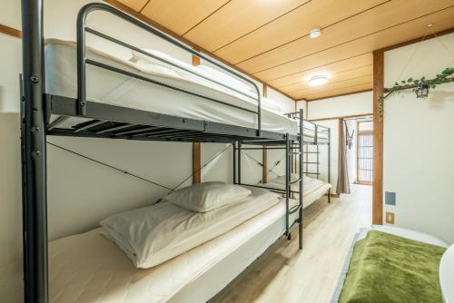 a bunk bed room with two bunk beds in a house at Guesthouse Ichiedo in Kashihara