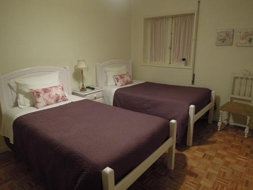 a hotel room with two beds and a window at Ester Guest House in Chaves