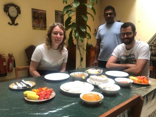 a group of three people sitting at a table with food at MALWATHTHA MOUNT VILLA KANDY in Kandy