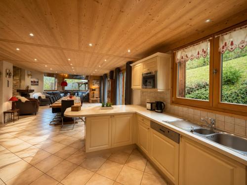a kitchen with a sink and a living room at Chalet Adonis - Montriond, Morzine, Avoriaz in Montriond
