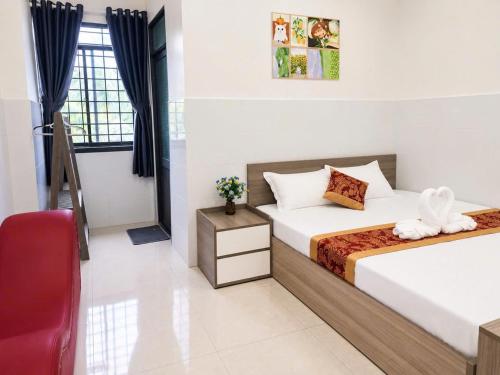 a bedroom with two beds and a red chair at Viora Hotel in Ấp Phước Thiện