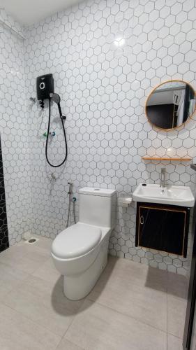a bathroom with a toilet and a sink at Dwan Hotel in Kota Bharu