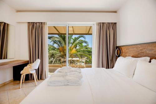 ein Schlafzimmer mit einem großen weißen Bett und einem großen Fenster in der Unterkunft Colonides Retreat Sea & Silence in Vounaria