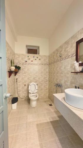 a bathroom with a toilet and a sink and a tub at Vanilla Homestay Da Lat in Da Lat