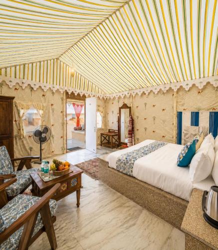 a bedroom with a bed and a living room at Desert Galaxy Camp - A Family Luxury Camp in Jaisalmer