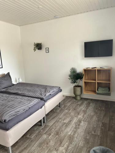 a bedroom with a bed and a flat screen tv at Varde Bed and Kitchen Annekset in Varde