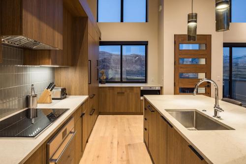 a kitchen with wooden cabinets and a sink and windows at LIONSBACK RESORT in Moab