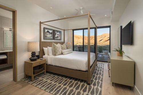 a bedroom with a canopy bed with a view at LIONSBACK RESORT in Moab