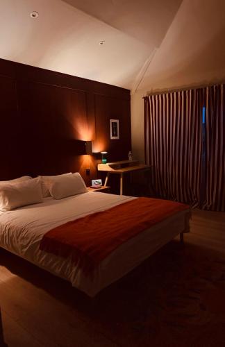a bedroom with a large bed and a desk at Maison RoHa - B&B & Wellness in Dinant