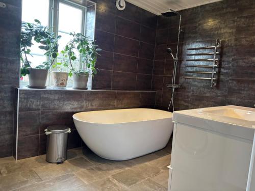 a bathroom with a large tub and a sink at Sjötomt med bastuflotte & badtunna - lantlig idyll in Vingåker