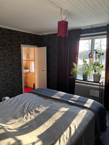 a bedroom with a bed with a blue blanket on it at Sjötomt med bastuflotte & badtunna - lantlig idyll in Vingåker
