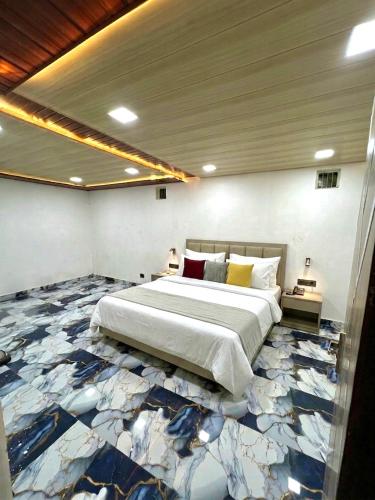 a bedroom with a large bed with a blue and white floor at The Palm Grove Farm Villa in Greater Noida