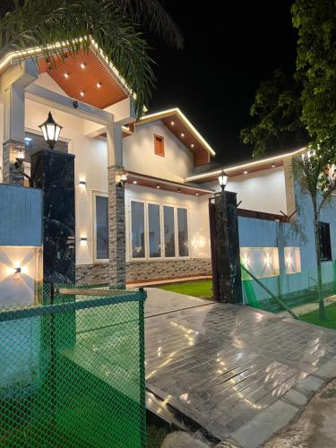 a house with a tennis court in front of it at The Palm Grove Farm Villa in Greater Noida