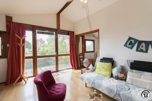 a living room with a couch and a chair at Framboisine in Cazères