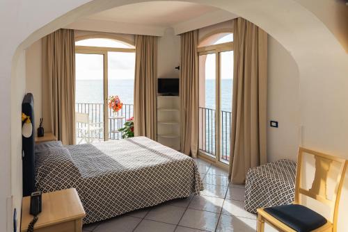 ein Schlafzimmer mit Bett und Balkon mit Meerblick in der Unterkunft Hotel Villa Iulia in Ventotene