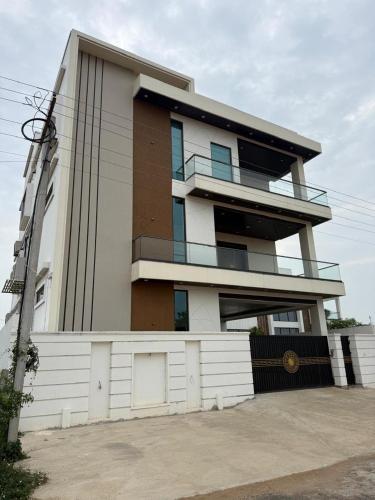 a building with a fence in front of it at Happy homes in Elūru