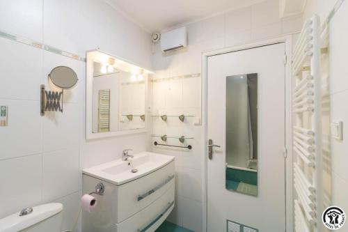 a white bathroom with a sink and a toilet at Julia in Aussonne