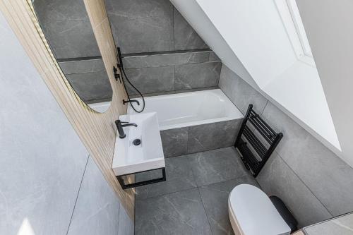 a bathroom with a sink and a bath tub at Penzión Šafrán in Ždiar