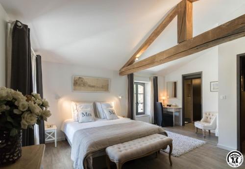 a bedroom with a large bed and a desk at Le sourire des anges in Saint-Élix-le-Château