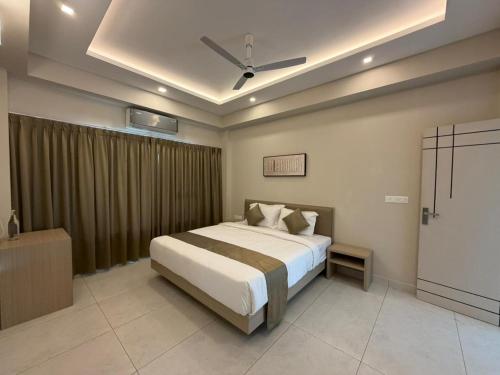 a bedroom with a bed and a ceiling fan at Aamys Home in Kalpetta
