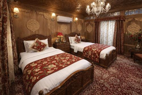 a bedroom with two beds and a chandelier at Chicago Group of Houseboats in Srinagar