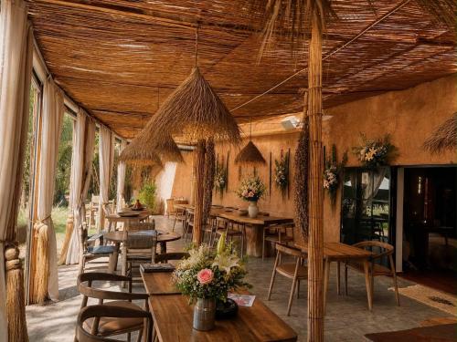 a dining room with wooden tables and chairs at La Ferme Berbere in Marrakesh