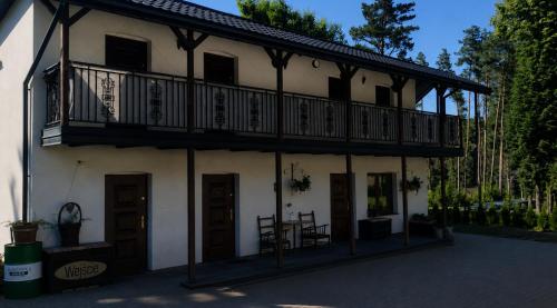 a building with a balcony on top of it at Karczma KOSZARKA in Ploski