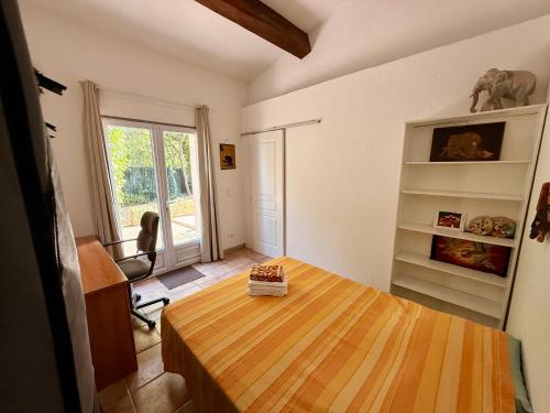 a small room with a wooden table and a window at Villa provençale La Banisté in Saint-Cézaire-sur-Siagne