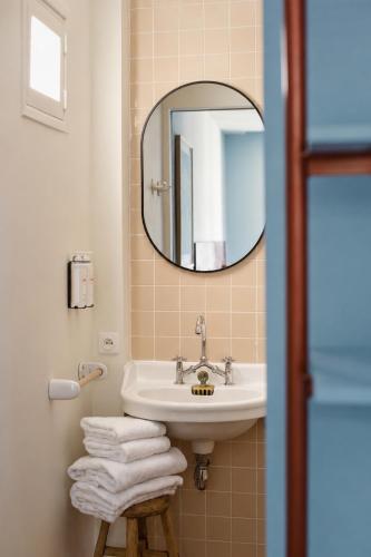 a bathroom with a sink and a mirror at Hôtel Le Voltaire in Arles