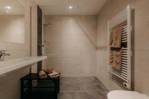 a bathroom with a sink and a tub and a toilet at Rössl Lodge in Gerlos