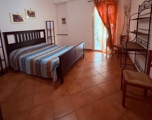 a bedroom with a bed and a tiled floor at Ciuscia 0 in Calatabiano