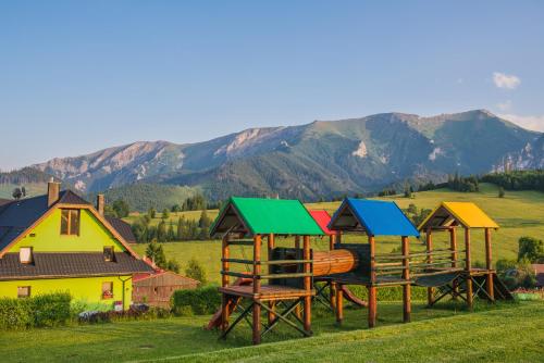 a group of wooden play structures in a field at Penzión Šafrán in Ždiar