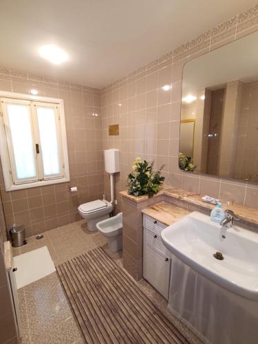 a bathroom with a sink and a toilet and a mirror at La Casa di Giovanni B&B in Romano D'Ezzelino