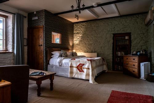 a bedroom with a bed and a table in a room at Ty Mawr, Brechfa in Carmarthen