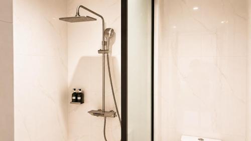 a shower with a shower head in a bathroom at H&H Boutique Hotel in Cukai