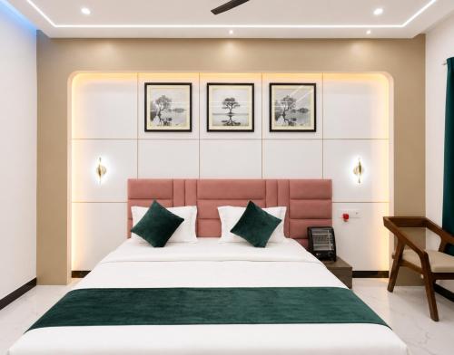 a bedroom with a large white bed with green pillows at Hotel Royal Awadh Near Shree Ram Mandir Ayodhya in Ayodhya