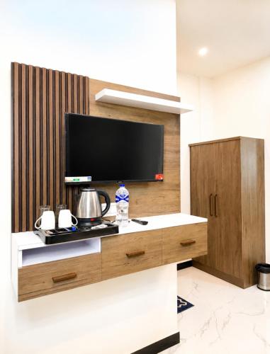 a living room with a flat screen tv on a wall at Hotel Royal Awadh Near Shree Ram Mandir Ayodhya in Ayodhya