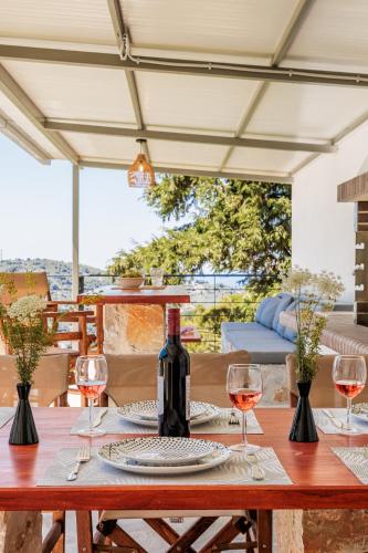 a wooden table with glasses of wine on it at Villa Theofilos in Glossa