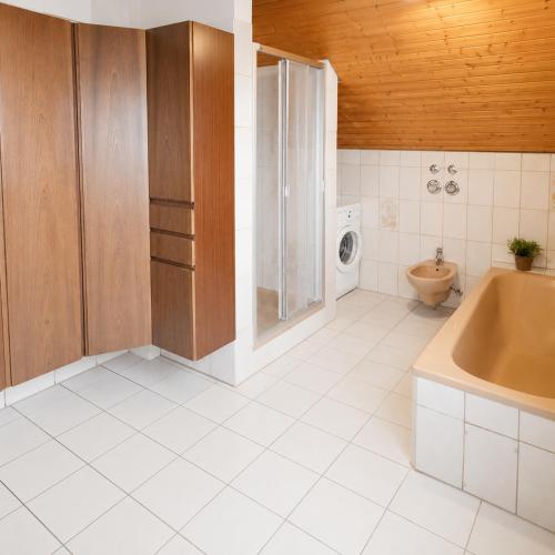 a bathroom with a tub and a toilet and a sink at Haus Rose in Allensbach