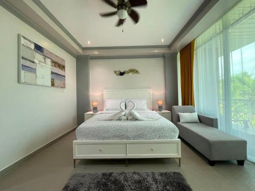 a bedroom with a bed and a chair and a ceiling fan at Green Field Resort Hotel in Anda