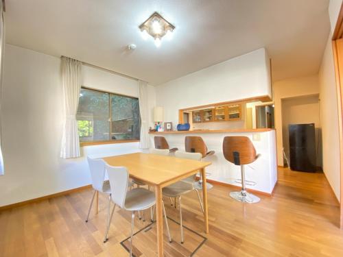 a kitchen and dining room with a table and chairs at トラストメゾン西伊豆 in Ukusu