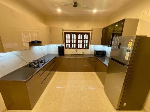 a large kitchen with a refrigerator and a sink at Tropical Haven in Panaji