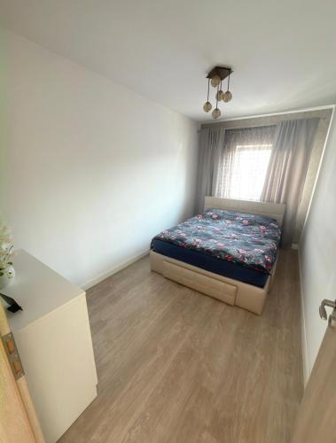 a small bedroom with a bed and a window at Cajara Home in Bucharest