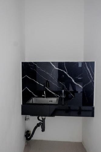 a bathroom sink with a black marble wall at Ocean River View in Ambalangoda