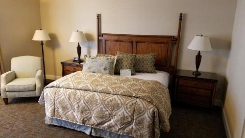 a bedroom with a bed and a chair and lamps at Chelsea Inn in San Francisco