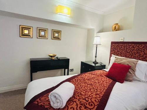 a bedroom with a bed with a red and white blanket at Benson House Box in Box